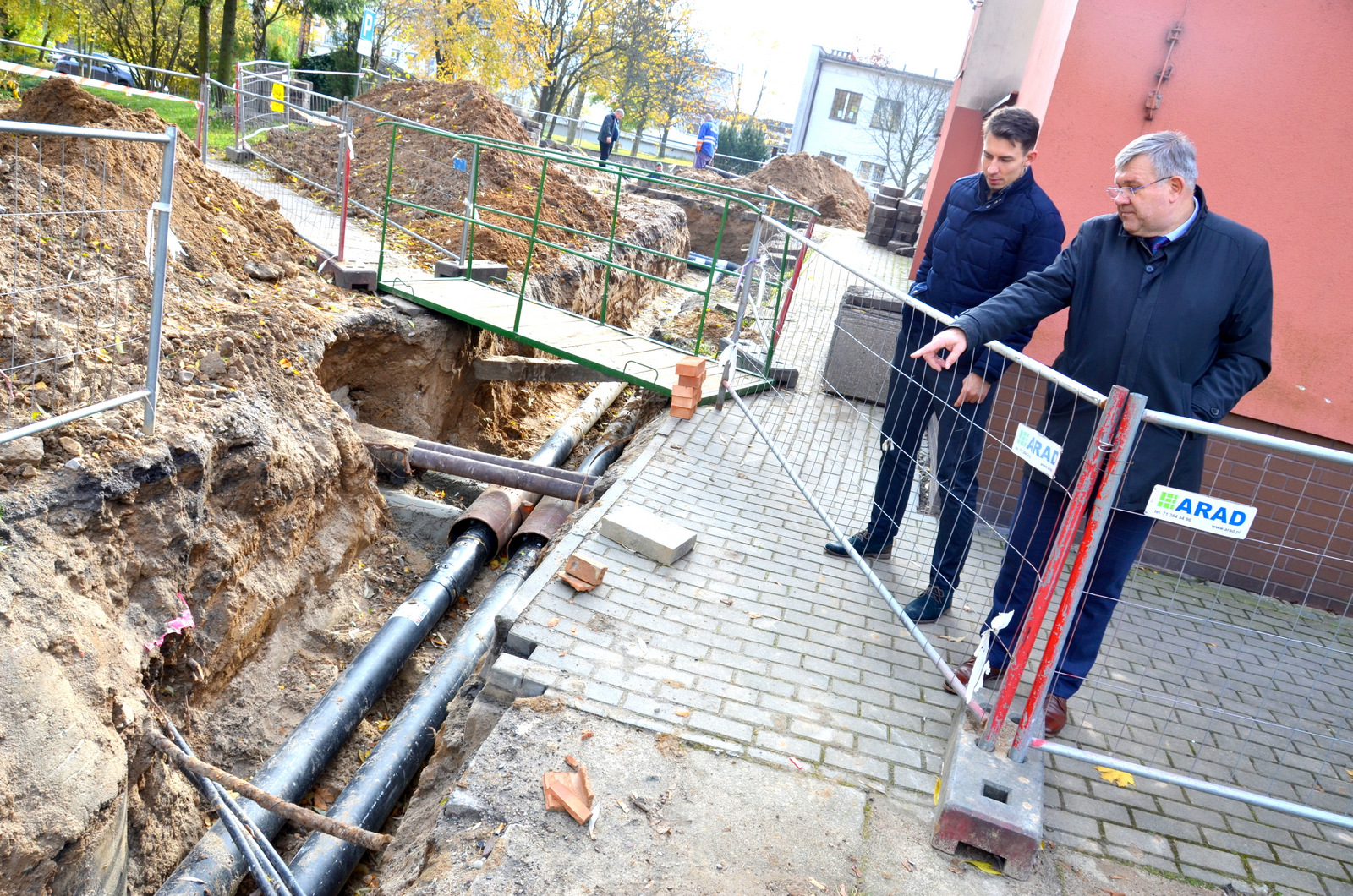 Budowa ciepłociągu. Stoją Burmistrz i Prezes