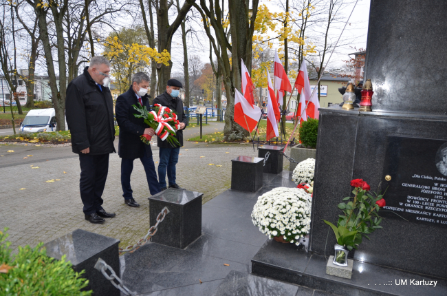 [Dla niewidomych: na zdjęciu Burmistrz kartuz, Wicestarosta Kartuski oraz radny Powiatu Kartuskiego podczas składania kwiatów pod pomnikiem Matki Boskiej w Kartuzach]