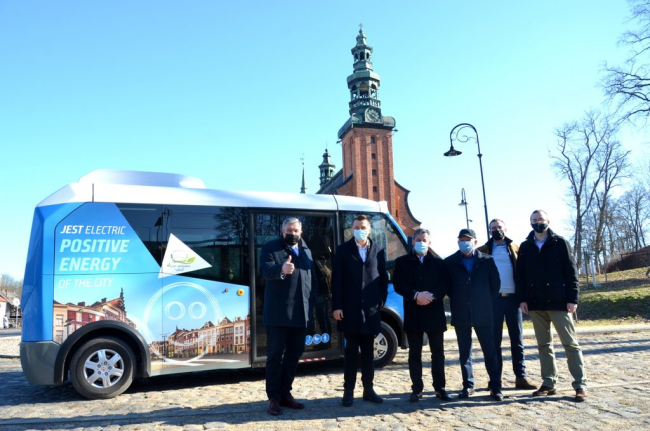 Zdjęcie grupowe na tle autobusu elektrycznego.